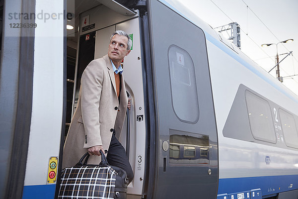 Geschäftsmann beim Aussteigen aus dem Personenzug