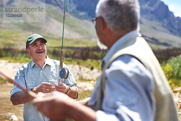 Lächelnde aktive ältere Männer beim Fischen