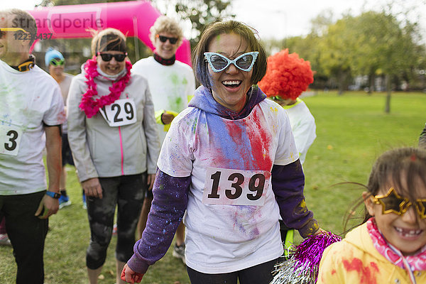 Portrait lächelnde  verspielte Läuferin mit alberner Sonnenbrille beim Charity-Lauf im Park