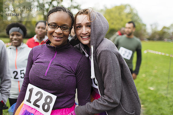 Portrait lächelnde  selbstbewusste Läuferinnen beim Benefizlauf im Park