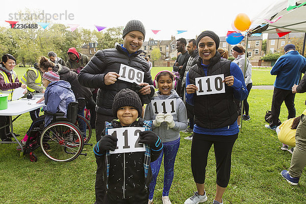 Porträt selbstbewusste Familienläufer mit Marathon-Lätzchen beim Charity-Lauf im Park