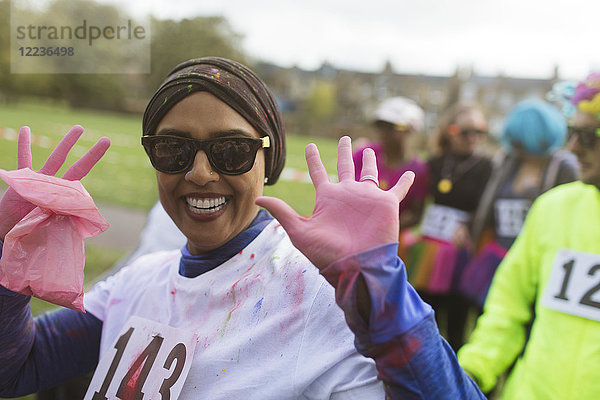 Portrait begeisterte Läuferin mit rosa Puderhänden beim Benefizlauf