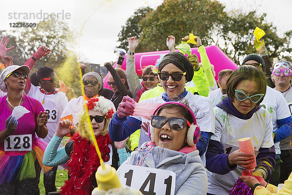 Portrait verspielte Läuferinnen und Läufer mit holi powder beim Charity-Lauf im Park