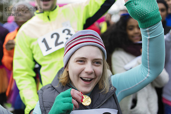 Enthusiastische Frau mit Medaillenjubel beim Charity-Rennen