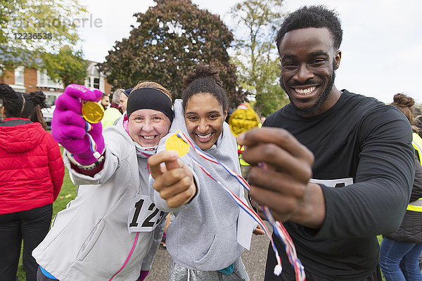 Portrait begeisterte Läuferinnen und Läufer mit Medaillen beim Benefizlauf im Park