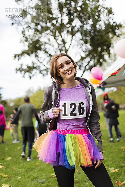 Portrait lächelnde  selbstbewusste Läuferin im Tutu beim Charity-Lauf im Park