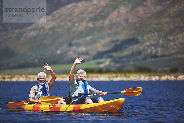 Porträt eines aktiven Seniorenpaares im Kajak auf dem sonnigen Sommersee