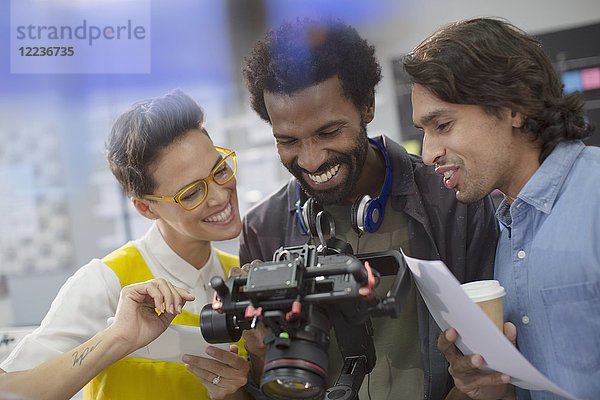 Lächelnde Journalisten und Kameramann mit Digitalkamera