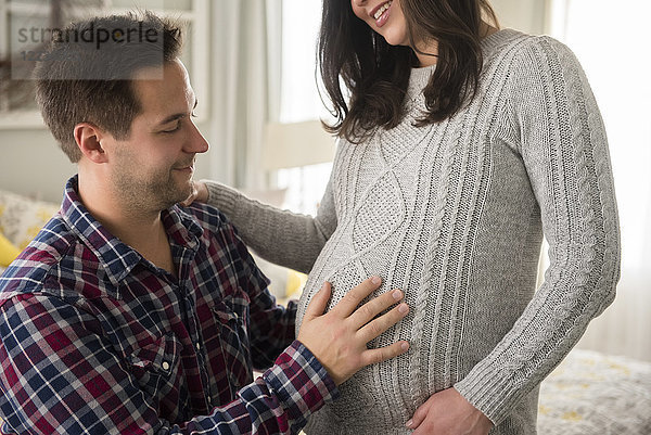 Mann berührt schwangere Partnerin