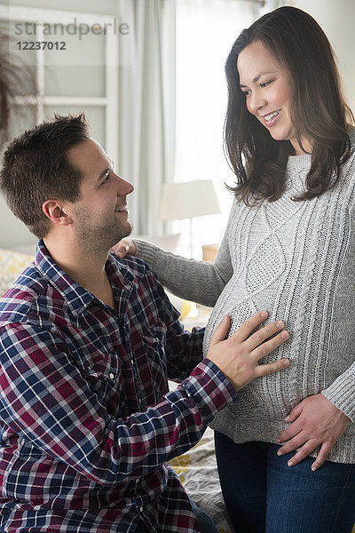 Schwangere Frau und Partner schauen sich an