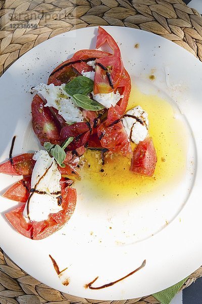 Tomaten mit Mozzarella auf einem Teller (Draufsicht)