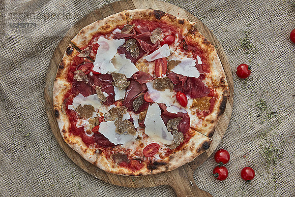 Eine Pizza mit Tomatensauce  Mozzarella  Bresaola  Trüffel und Parmesan