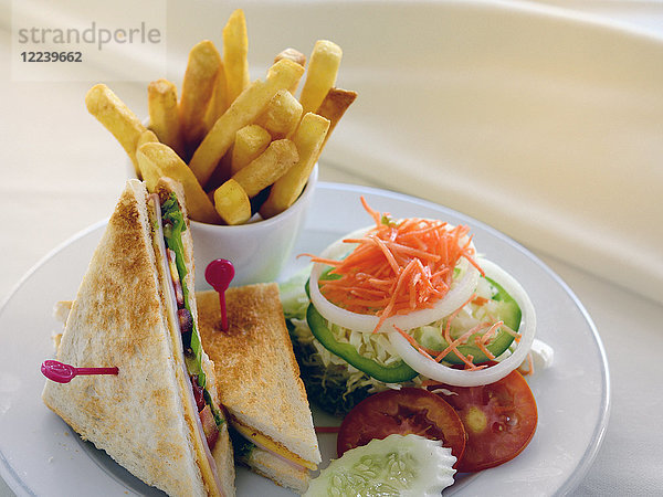 Ein Club-Sandwich mit Salat und Pommes frites