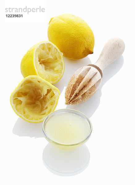 Zitronensaft und eine entsaftete Zitrone