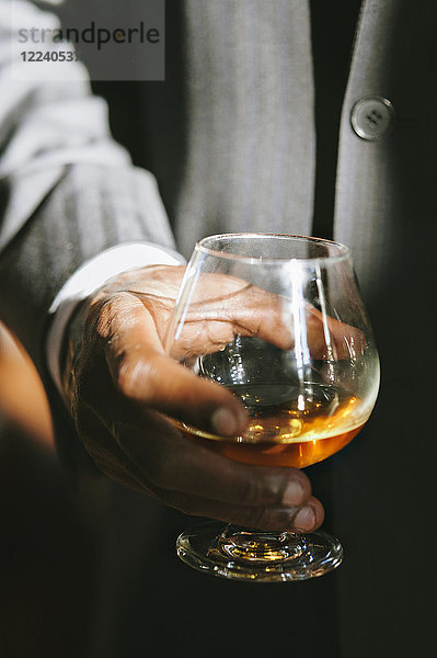 Ein Mann hält ein Glas Bourbon