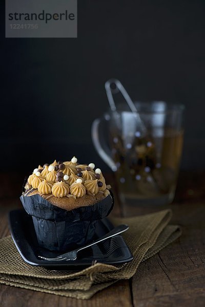 Ein gesalzener Karamell-Cupcake mit einer Tasse Kräutertee