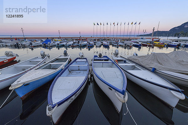 Hafen mit Reihen von angedockten Fischerbooten am Gardasee (Lago di Garda) in der Morgendämmerung in Garda in Venetien  Italien