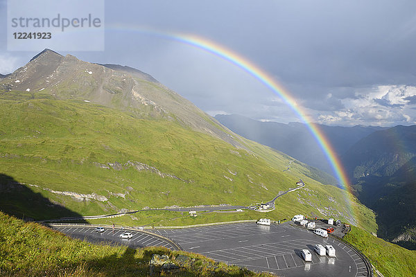 Regenbogen über Berglandschaft mit Parkplatz auf Kaiser Franz Josefs Hohe in Großglockner Hochalpenstraße im Nationalpark Hohe Tauern  Kärnten  Österreich