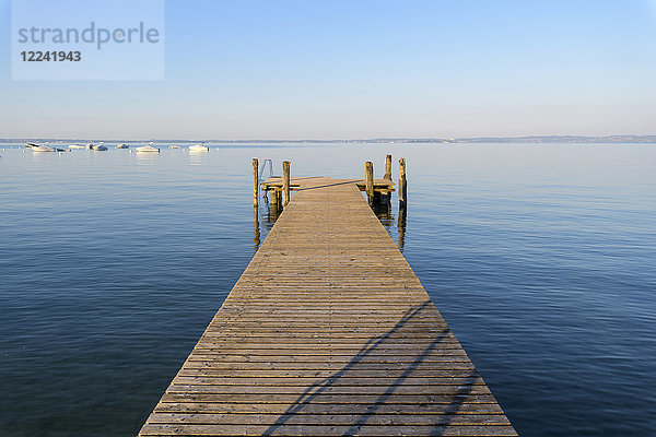 Holzsteg am Gardasee (Lago di Garda) an einem sonnigen Morgen in Bardolino in Venetien  Italien