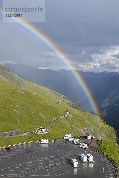 Regenbogen über Berglandschaft mit Parkplatz auf Kaiser Franz Josefs Hohe in Großglockner Hochalpenstraße im Nationalpark Hohe Tauern  Kärnten  Österreich