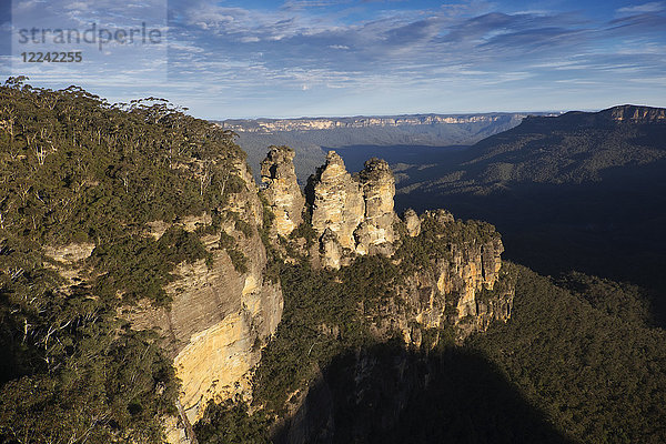 Sonnenlicht  das sich in den Felsformationen der Three Sisters spiegelt  und malerische Aussicht auf den Blue Mountains National Park in New South Wales  Australien
