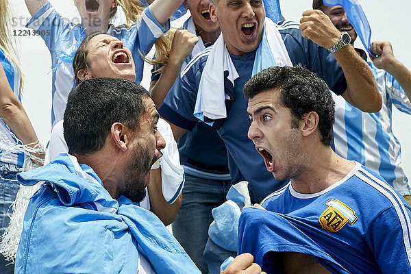 Argentinische Fußballfans jubeln beim Zuschauen des Fußballspiels