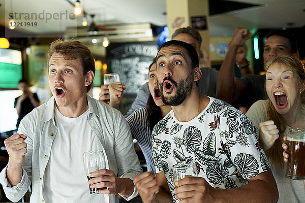 Fußballfans beim gemeinsamen Spiel in der Kneipe