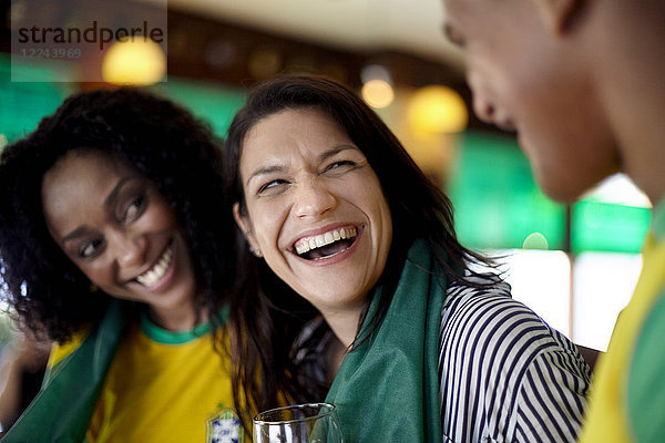 Frau lacht in der Bar mit Freunden