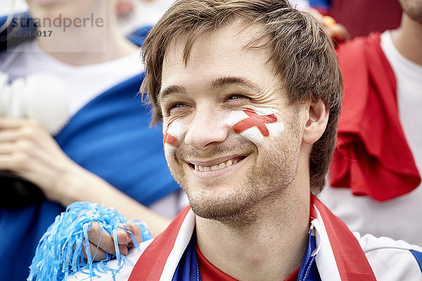 Britischer Fußballfan lächelt fröhlich beim Spiel  Porträt