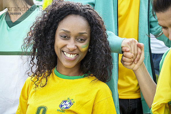 Brasilianischer Fußballanhänger lächelt fröhlich  Porträt