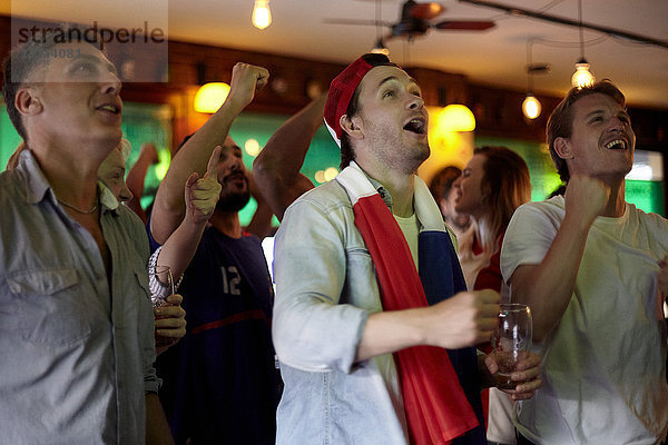 Französische Fußballfans beobachten das Spiel in der Bar