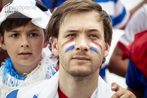 Vater und Sohn beobachten ängstlich das französische Fußballspiel
