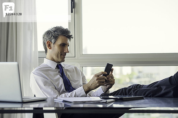 Mann mit Smartphone im Büro