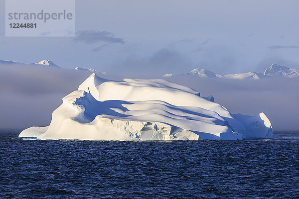 Riesiger Eisberg  Abendlicht  sich auflösender Nebel  Bransfield Strait  nahe South Shetland Islands und Antarktische Halbinsel  Antarktis  Polargebiete