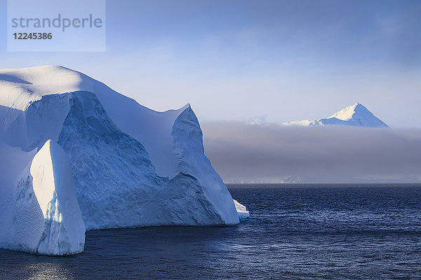 Riesiger Eisberg und Berg  sich lichtender Nebel  Bransfield Strait  in der Nähe der Süd-Shetland-Inseln und der Antarktischen Halbinsel  Antarktis  Polarregionen