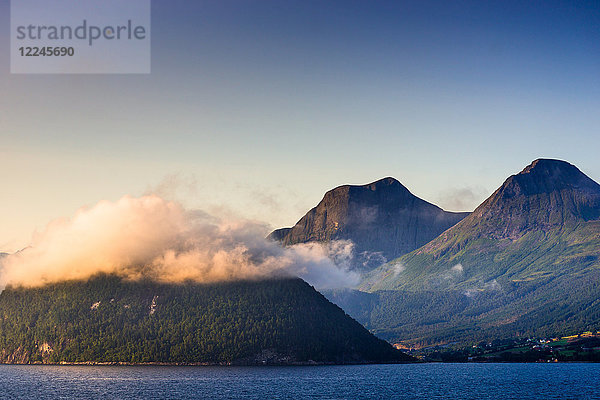 Niedrige Wolken fangen die untergehende Sonne am Nordfjord ein  Norwegen  Skandinavien  Europa
