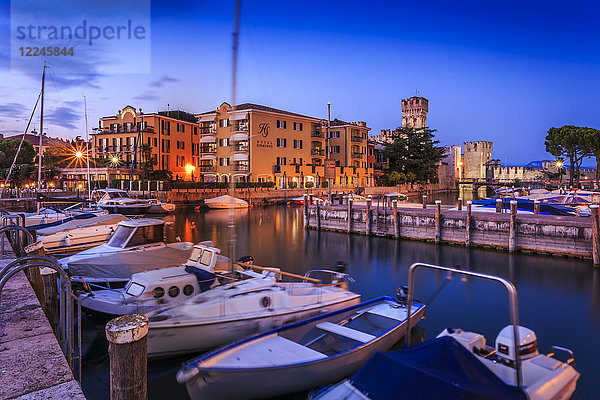 Blick auf die Scaligerburg und Boote im Hafen in der Abenddämmerung  Sirmione  Gardasee  Lombardei  Italienische Seen  Italien  Europa