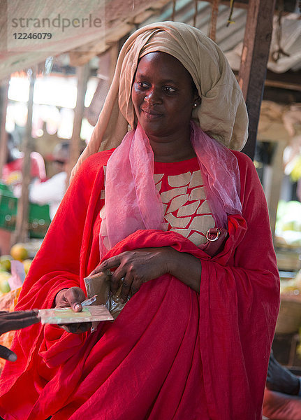 Eine farbenfroh gekleidete Frau auf dem Markt in Stone Town  Sansibar  Tansania  Ostafrika  Afrika