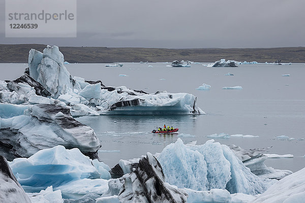 Boot inmitten von gekalktem Eis des Breidamerkurjokull-Gletschers in der Gletscherlagune Jokulsarlon  Island  Polarregionen