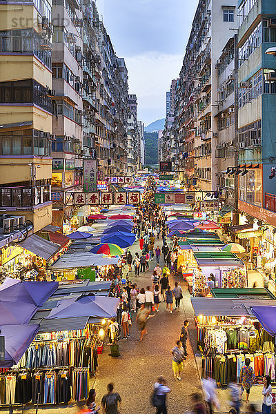 Eine belebte Marktstraße in Mong Kok (Mongkok) beleuchtet in der Abenddämmerung  Kowloon  Hongkong  China  Asien