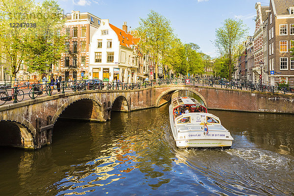 Ein Boot fährt unter einer Brücke über den Keizersgracht-Kanal  Amsterdam  Niederlande  Europa