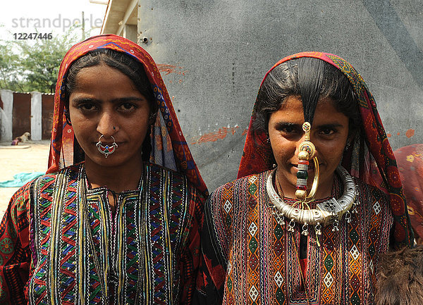 Zwei junge Jat-Frauen  eine trägt den traditionellen Nasenring der Jat-Stämme  Schmuck und Kleidung aus Messing  Dorf Bhidara  Kutch  Gujarat  Indien  Asien