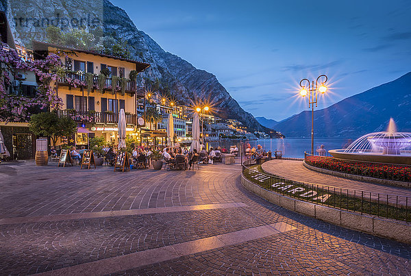 Blick auf die beleuchtete Promenade am Hafen von Limone in der Abenddämmerung  Gardasee  Lombardei  italienische Seen  Italien  Europa