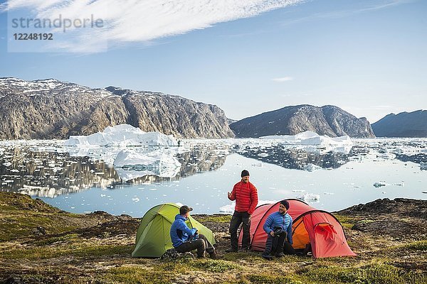 Drei Personen mit Zelten  rot und grün  Berge  Fjord mit Eisbergen  Grönland  Nordamerika