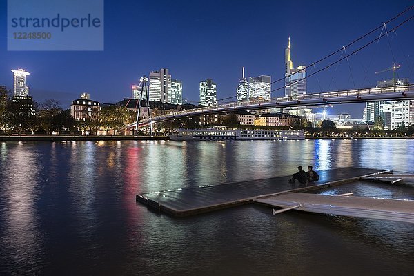 Holbeinsteg  Fußgängerbrücke über den Main mit einer Skyline in der Abenddämmerung  Frankfurt am Main  Hessen  Deutschland  Europa