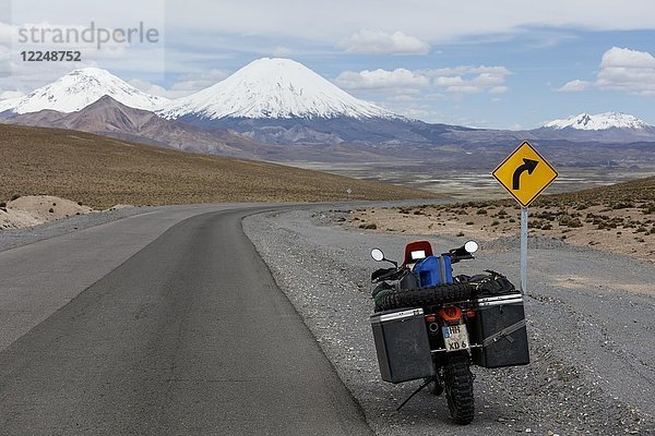 Schwer bepacktes Motorrad am Straßenrand hinter dem Vulkan Pomerape  Putre  Region de Arica y Parinacota  Chile  Südamerika