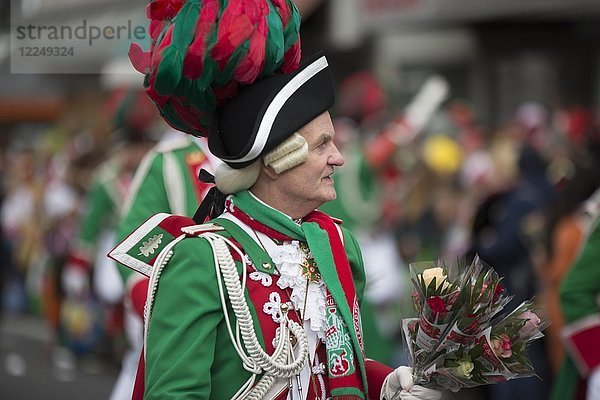 Karnevalskünstler in grüner Uniform mit Blumenstrauß  Rosenmontagsumzug  Köln  Nordrhein-Westfalen  Deutschland  Europa