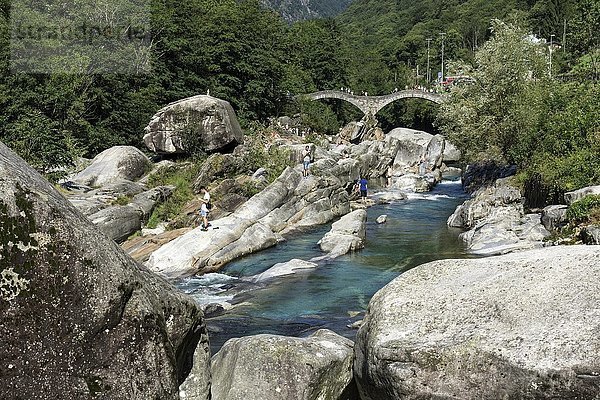 Felsformationen  badende Menschen in Verzasca bei Lavertezzo  im Hintergrund die römische Brücke Ponte dei Salti  Verzascatal  Valle Verzasca  Kanton Tessin  Schweiz  Europa