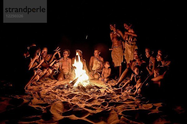 Buschmänner der Ju/' Hoansi-San am Lagerfeuer sitzend  Dorf //Xa/oba  bei Tsumkwe  Otjozondjupa-Region  Namibia  Afrika