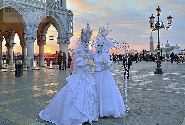 Verkleidetes Paar mit venezianischen Masken bei Sonnenuntergang  hinter der Insel San Giorgio  Karneval in Venedig  Italien  Europa